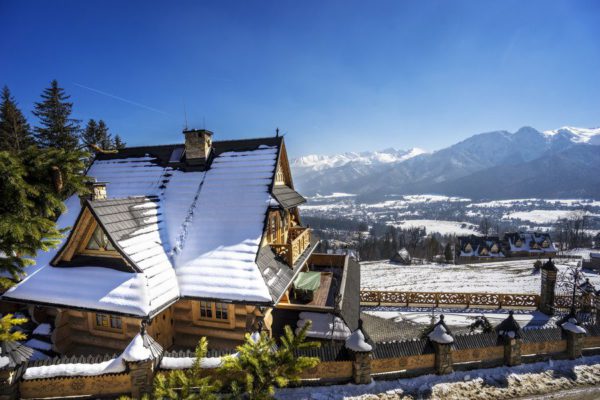 Dom Tatra SKI Chalet z zewnątrz, na drugim planie ośnieżone góry