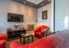 Apartament Bordeaux - salon, sofa, fotel, stolik kwaowy, telewizor na ścianie 