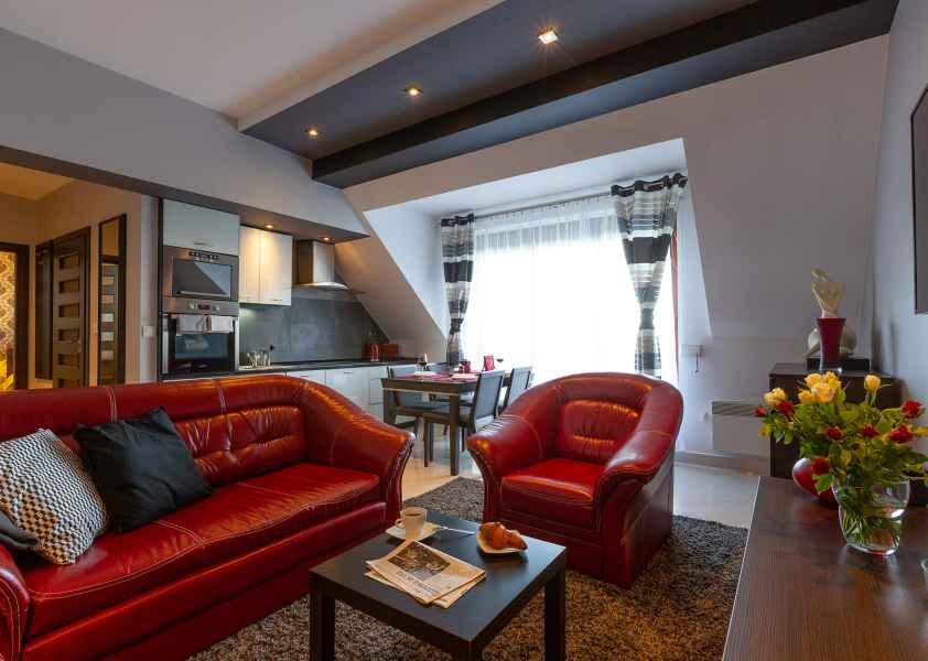 Apartament Bordeaux - salon z sofą, fotelem i stolikiem kawowym